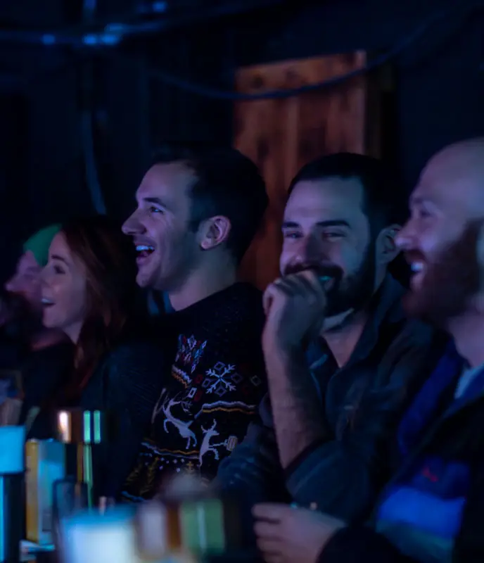 a group of people sitting in a row watching comedy