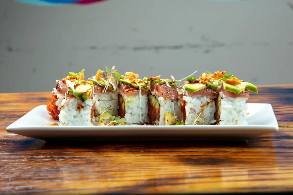 a plate of sushi on a wood table