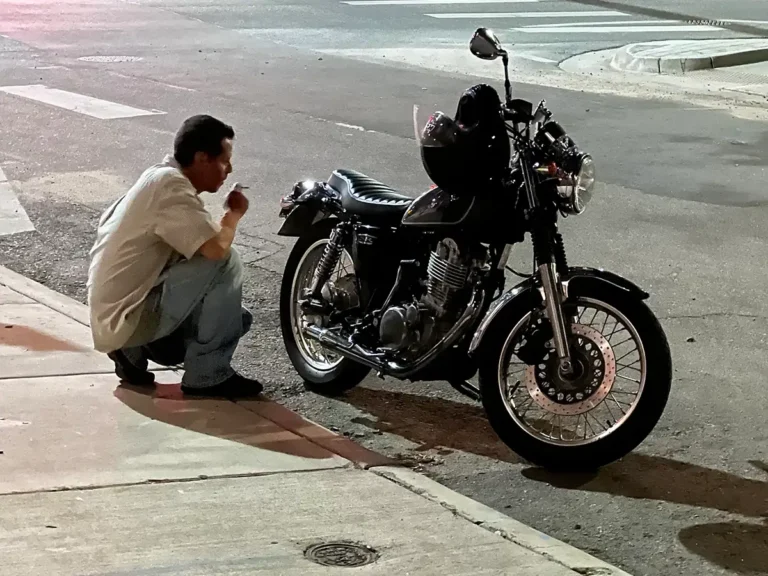 a man kneeling next to a motorcycle