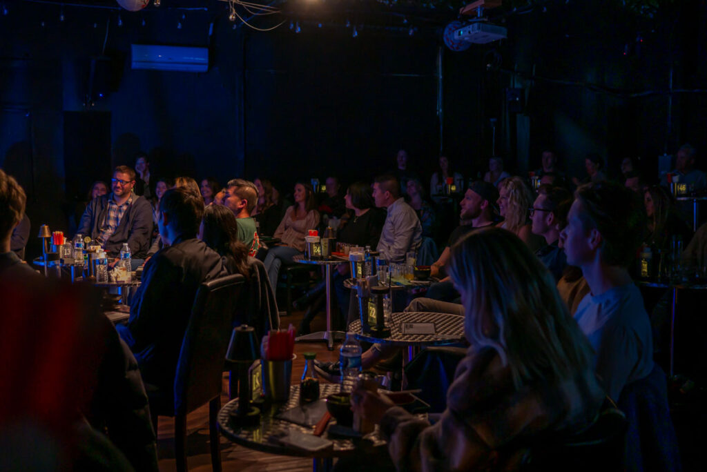 Comedy Club patrons eating dinner at the Denver Comedy Lounge during a live show.